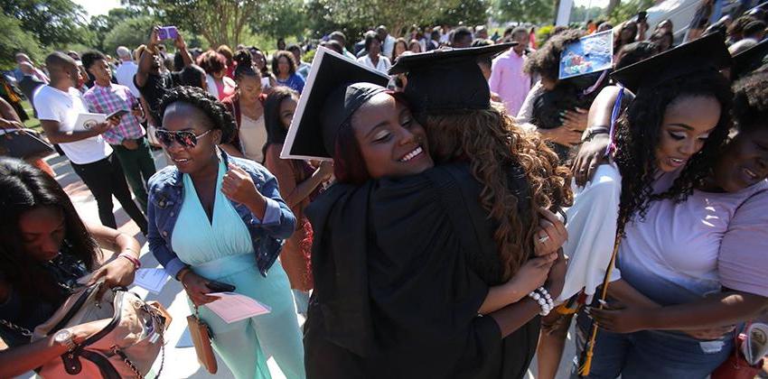 Two students hugging during graduation