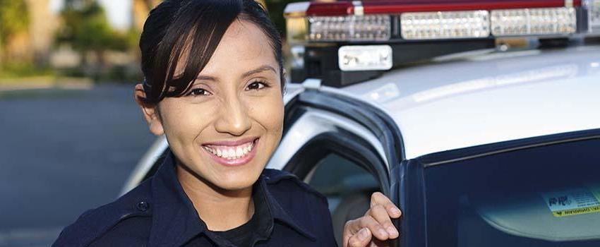 Smiling Female Police Officer in front of her car